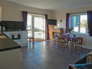 Dining table, chairs, sofa, bookcase, nest of tables and kitchen area