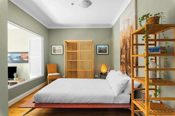 The bedroom has bifold privacy shutters, an ambient warm side lamp and striking wall art that brings character to the room. 
