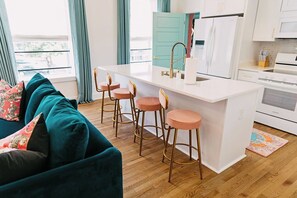 Spacious open concept living room/kitchen with island & 4 bar stools, 75" TV.