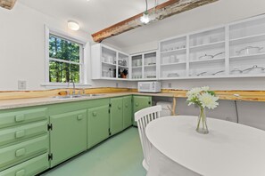 Kitchen has refrigerator, freezer, sink, microwave, and 2-burner cooktop