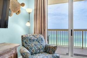 Living Room - Relax in this coastal living space featuring a large flat-screen TV, beautiful decor, and a private balcony with breathtaking beach views.