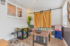 Game room with foosball and arcade game and basketball hoop