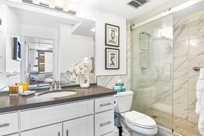 Refreshed in your bathroom with a walk-in shower and a vanity with a cabinet.-