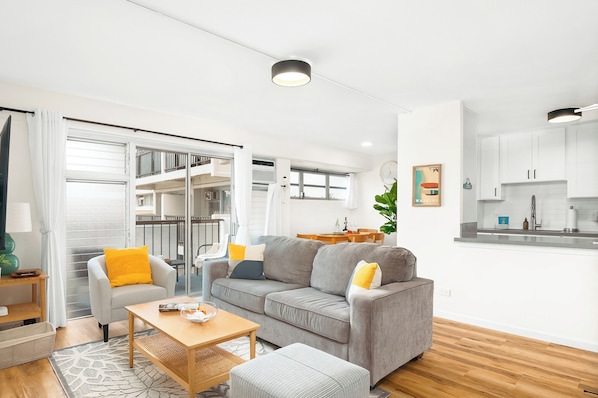 Living room with a queen-size pull-out sleeper sofa, a 75'' smart TV, and a beautiful mountain view.