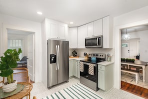 Convenient kitchen with microwave, fridge, and oven to cook, store, and heat your meals anytime.