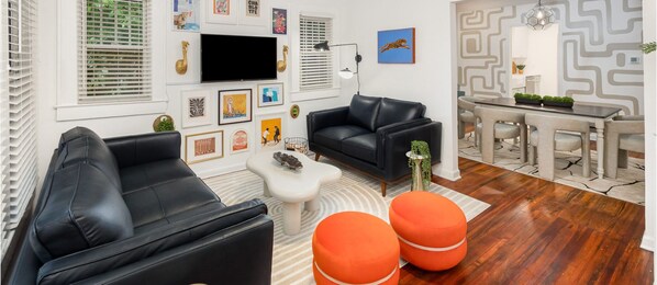 Unique and stylish living room with TV, flowing effortlessly into the dining room. Enjoy a Virtual Tour by scaning the QR Code.