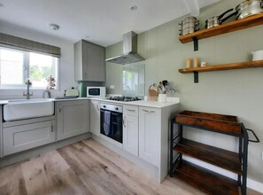 Kitchen with elective oven, and gas hob.