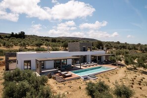 This two-building villa offers 2 kitchens, 2 living rooms, 2 dining areas, and 4 bedrooms that can comfortably accommodate up to 10 guests.