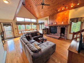 Open living area with sectional sofa, fireplace and TV adjacent to Kitchen and Dining areas