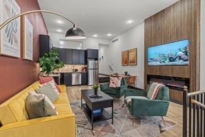 You'll be captivated by this stylish open-concept space where vibrant colors and modern design elements blend seamlessly. Enjoy the cozy seating, charming decor, and the stunning fish tank that adds a unique touch of tranquility.