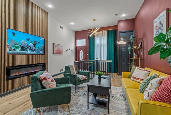 Step into elegance and comfort in this beautifully designed living room. You'll love relaxing on plush furniture while enjoying the warmth of the modern fireplace and the vibrant fish tank display on the Roku Smart TV. Every detail invites you to unwind.