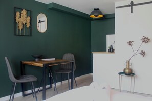 Chic dining area in Tilburg featuring vibrant green walls and elegant decor, perfect for enjoying meals or working.