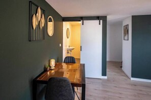 Charming dining area in Tilburg with bold green walls and minimalist furnishings for a cozy experience.