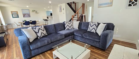 Large open Living & Dining Room with large screen smart TV in corner.