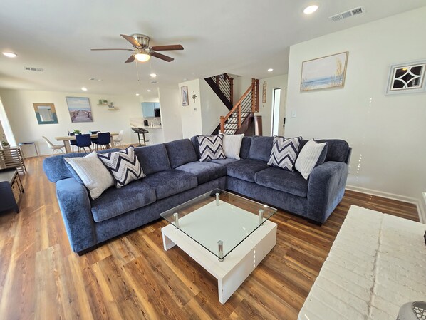 Large open Living & Dining Room with large screen smart TV in corner. 