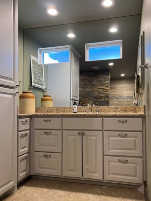 The expansive bathroom includes a large vanity and storage. The first aid kit is stored in the right-side drawer.