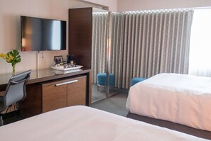 Streamlined and welcoming room featuring two beds and a convenient workspace, perfectly suited for both leisure and business travelers.