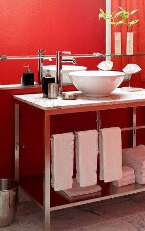 Refreshingly modern bathroom with bright red walls and contemporary amenities, offering a vibrant start to your day.