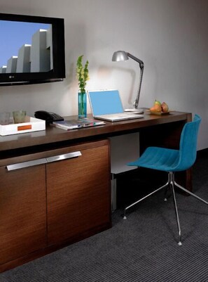 Practical workspace equipped with a sleek desk and vibrant chair, ideal for staying productive in a comfortable setting.