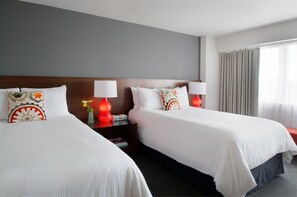 Spacious and comfortable room featuring plush bedding and vibrant decor, ideal for friends or family seeking a shared yet stylish stay.