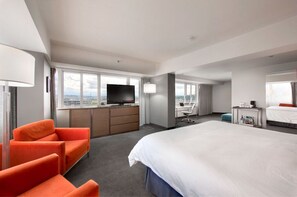 Step into our minimalist room with plush bedding and bright seating, designed for a restful and rejuvenating stay.