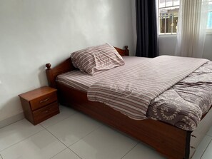 A spacious room with a private bathroom, featuring a mirror, a hot water shower, and a wardrobe.