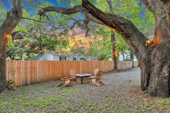 Experience the magic of this fire pit, situated under a majestic live oak with overhead lights.