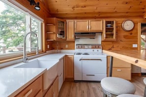 **Charming Kitchen with Modern Amenities**: "Our charming kitchen offers modern amenities and a cozy atmosphere, perfect for preparing meals and enjoying the view.