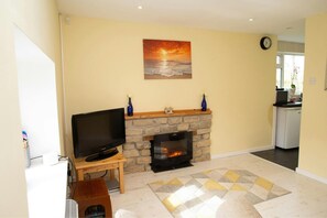 Living room with Smart TV on stand. Fireplace and mantle