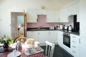 Kitchen dining area in Beudy Nel with fitted units, dining table and chairs