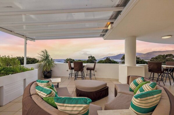 Relax on your private balcony, taking in stunning mountain and ocean views—best enjoyed at sunset.
