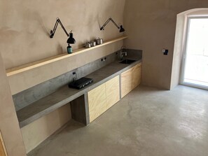 The Kitchen Space made by Concrete inside the Living Room