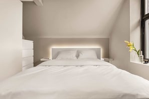 The light positioned behind the bed doubles as a convenient reading lamp. Furthermore, ample closet space is available for unpacking your belongings! And with this cozy 160 cm bed, you'll drift off to sleep in no time! | Bedroom 1