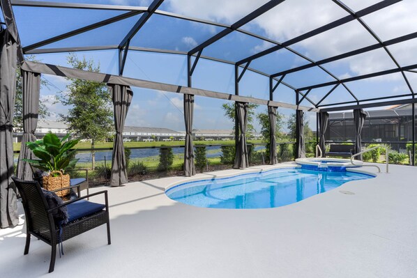 Screened pool and spa with water views, lounge seating, and total privacy.