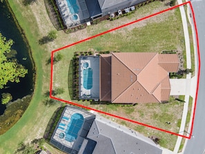 Expansive corner-lot home with private screened pool and serene water views.