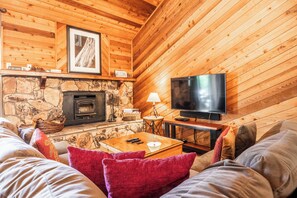 Living room, wood burning fireplace, flatscreen TV, shuffleboard