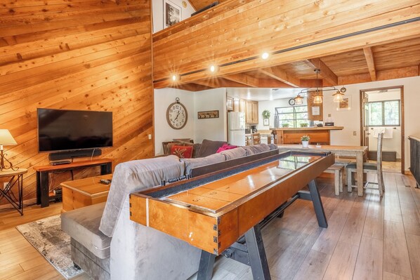 Living room, wood burning fireplace, flatscreen TV, shuffleboard