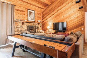 Living room, wood burning fireplace, flatscreen TV, shuffleboard