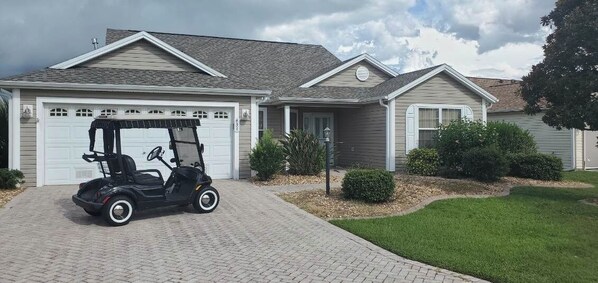 The outside view of the 3 bedroom -2 bath home with 2 car garage and Golf Cart!