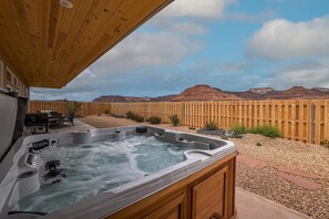 Relax in the private luxury hot tub on the back patio with red rock views.