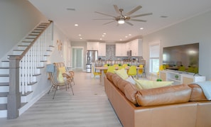 The living and dining area, with dining seating for 16, couch, and 70” Roku TV