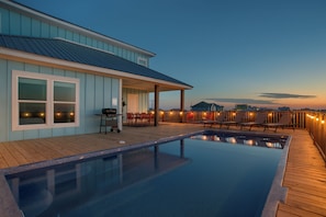 Private sparkling pool at sunset, located on the back deck, with lounge area.
