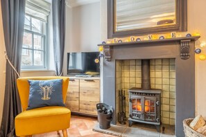 Teacup Cottage, Syderstone: A cosy corner in the sitting room with multi fuel stove