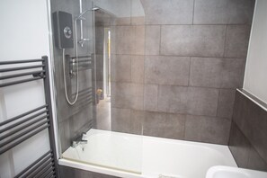 En suite with electric shower over the bath. Heated towel rail