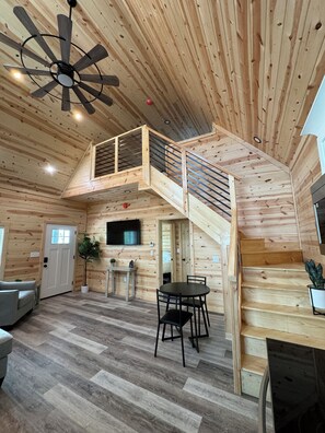 View of living room from kitchen. Open concept and stairs leading up to the loft