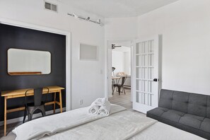 Guest bedroom with full bed, sofa bed,  workspace, and clothing storage.      