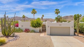 Adobe style home with mountain backdrop and a southwestern desert look 
