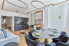 Salon avec canapé lit avec cuisine américaine équipée