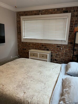 Bedroom 2 with dresser, closet, TV, laundry, and ceiling fan