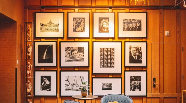 A wall adorned with an array of framed photographs and art adds a personal touch to our lobby, creating a space that's as much a gallery as it is a welcoming area.